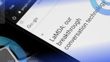 A smartphone screen with "LaMDA: our breakthrough conversation technology" and the Google logo on it