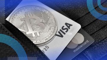 A physical Bitcoin coin and credit cards in a wallet.