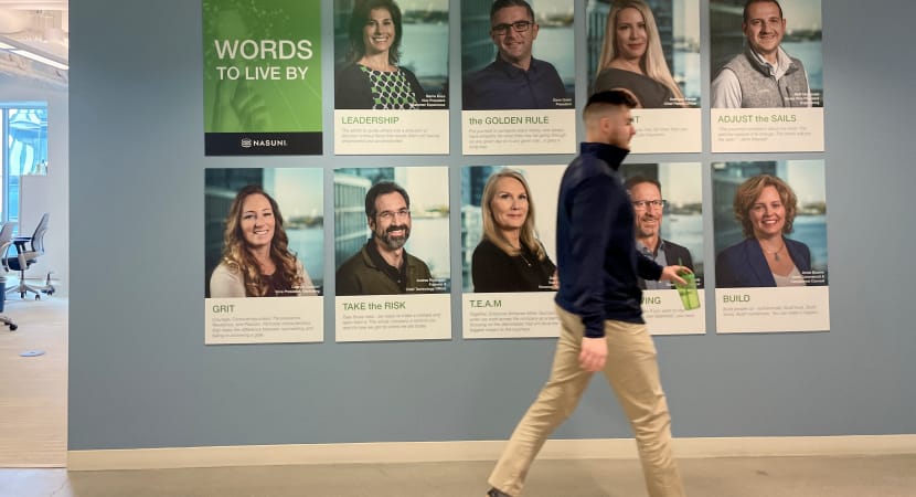 Employee walks by inspirational Words to Live by wall