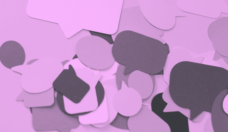 A purple-toned image of speech bubbles cut out of multicolored construction paper. /corporate-innovation/minimum-viable-sentence 