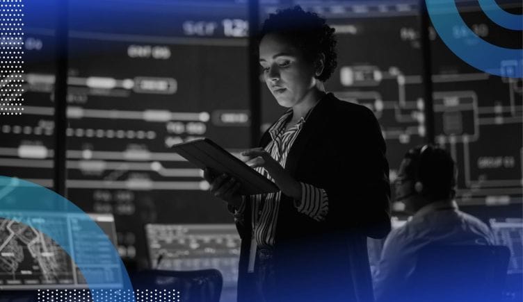 A woman uses a tablet in a data-filled command center for a public transit system. /big-data/top-roles-responsibilities-salaries