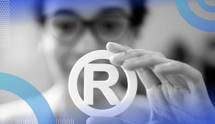 A woman holds a trademark symbol.