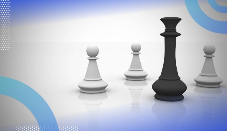 A black queen chess piece stands in front of three white pawn chess pieces. /career-development/when-how-develop-influence