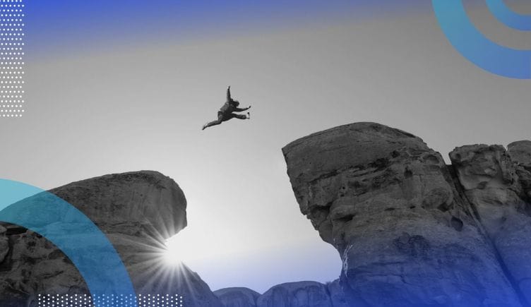An adventurer jumps from one rock outcropping to another