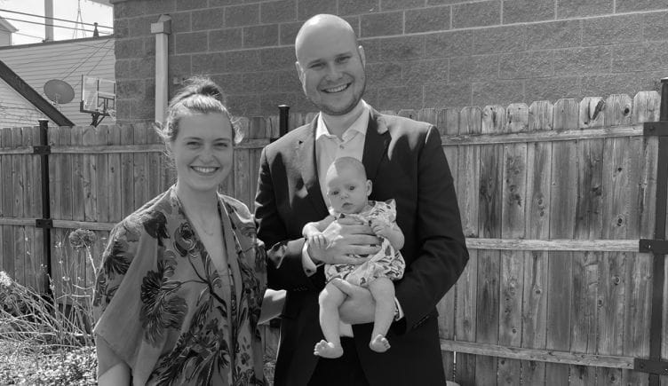 Affirm team member standing with his wife and holding his their baby