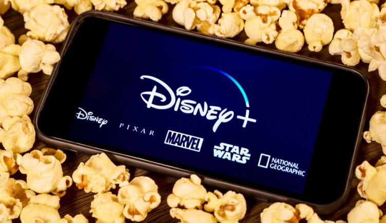 iPhone showing Disney+ surrounded by popcorn