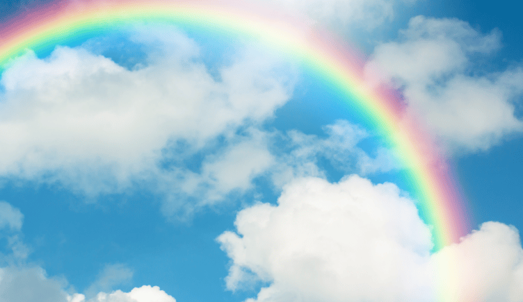 A rainbow and clouds against a blue sky