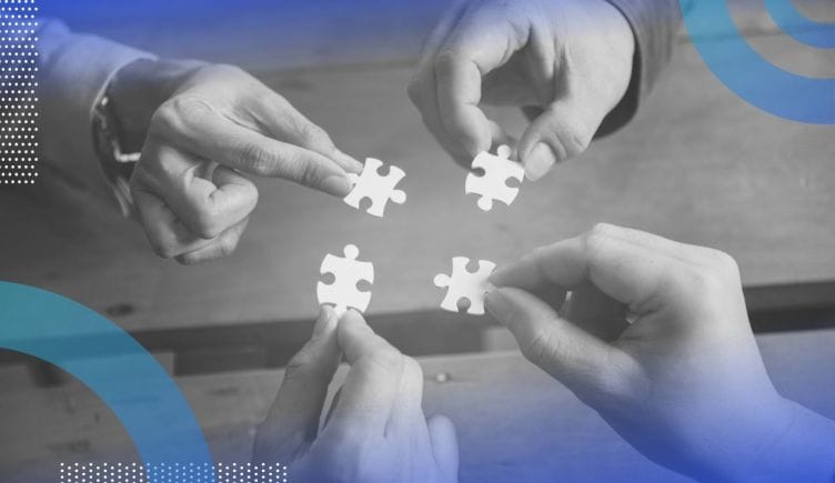 Four different hands hold matching puzzle pieces, close to bringing them together. /people-management/4-keys-relational-intelligence