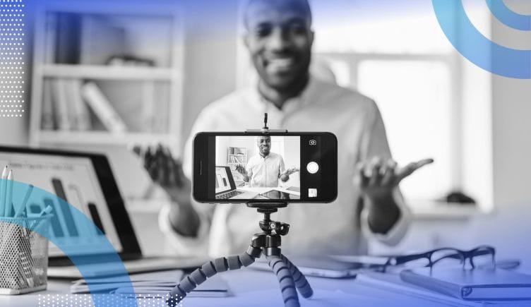 A cell phone on a tripod captures video of a man making a presentation. /marketing/influencers-go-corporate