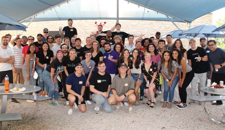 The GetSales team poses for a group photo on a beach at a crawfish boil