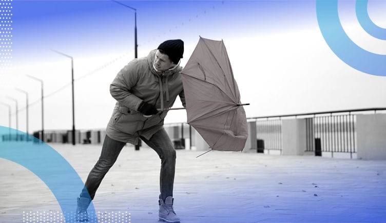 A man battles the wind that is collapsing his umbrella