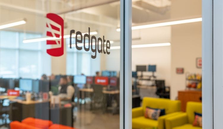 logo of redgate on glass door with view of office