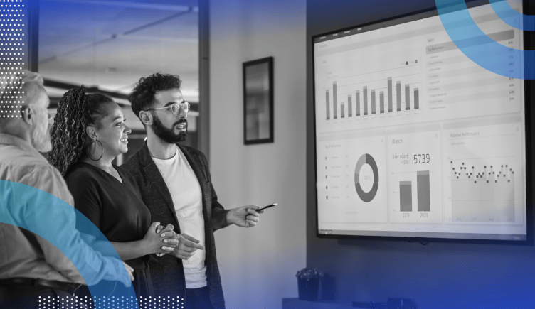 Marketing Operations image of two men and a woman looking at a television with a data presentation. 