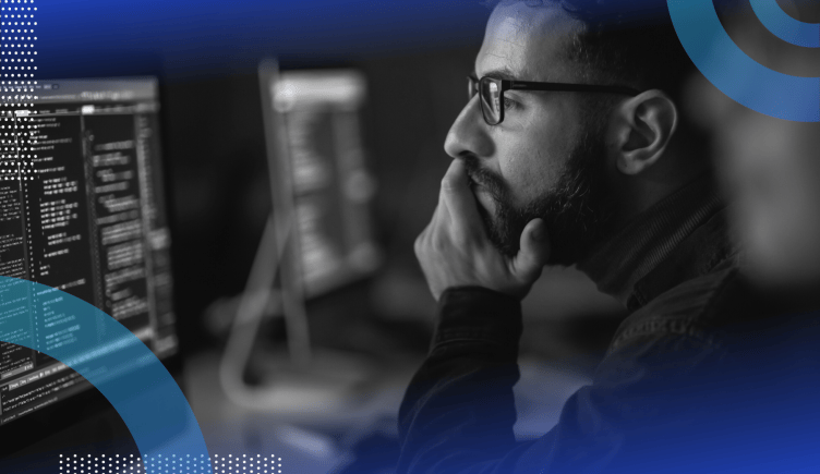 Software requirement specification image of a bearded man wearing glasses holding his chin and looking at a screen as though studying or reading something