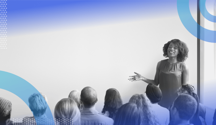 Employee training image of a woman standing in front of a group of people speaking and gesturing