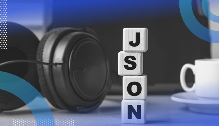 JSON image of a pair of headphones and a cup of coffee on a desk. In between them we see a pair of blocks stacked vertically spelling out J S O N