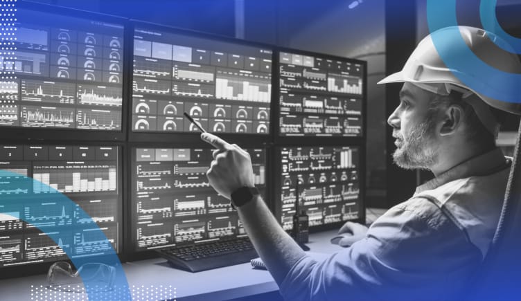 SCADA image of a person wearing a hardhat monitoring 6 computer screens full of incoming data.