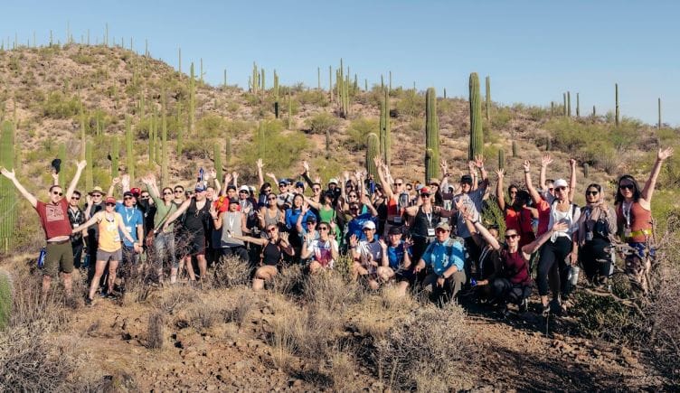 Large group of Paper team members posing for a picture in a desert landscape with cacti
