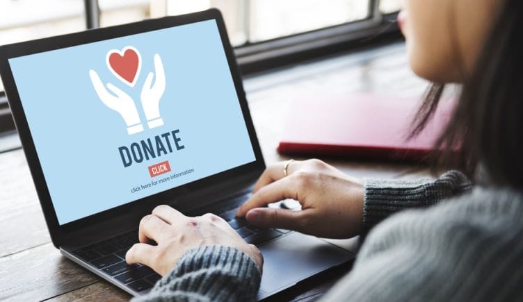 An employee makes an online donation on their laptop.