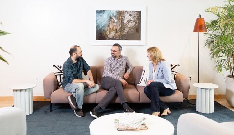 Muammer Akgün, Erhan Musaoglu and Elizabeth Walsh site on a couch in Logiwa’s office, talking.