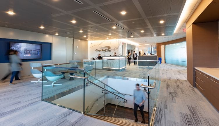  Photo of Capital One offices showing staircase, reception desk and people moving about 