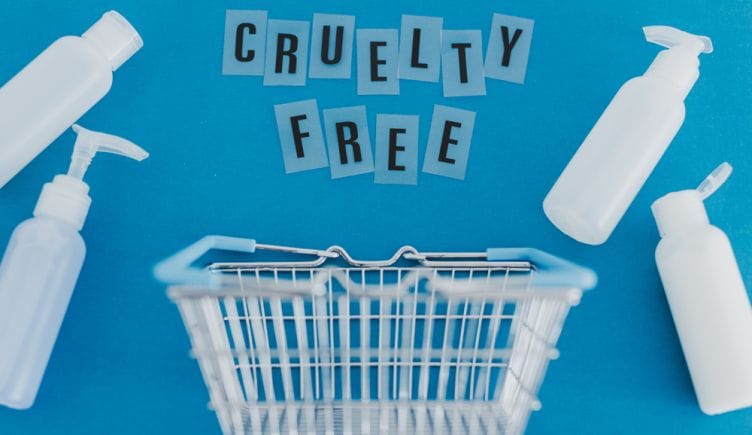 Empty product bottles surround a grocery basket with the phrase Cruelty Free hovering over it.