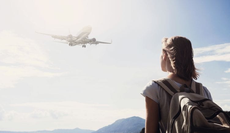 woman looking at plane taking off