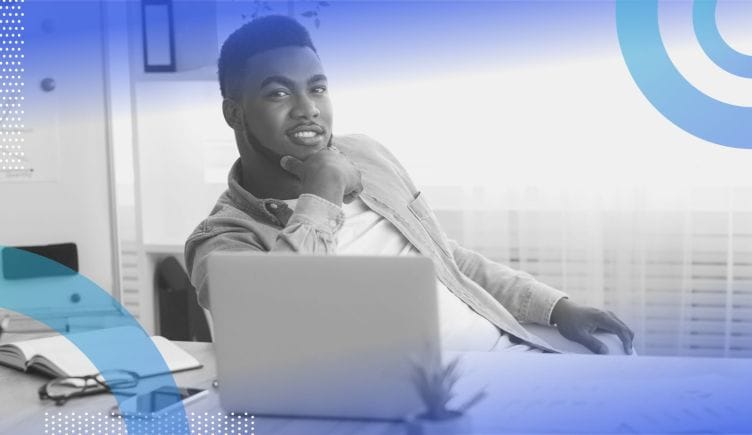 a Black businessperson at a computer. Hiring Black-owned vendors and visiting Black-owned businesses can help build wealth in the Black community.