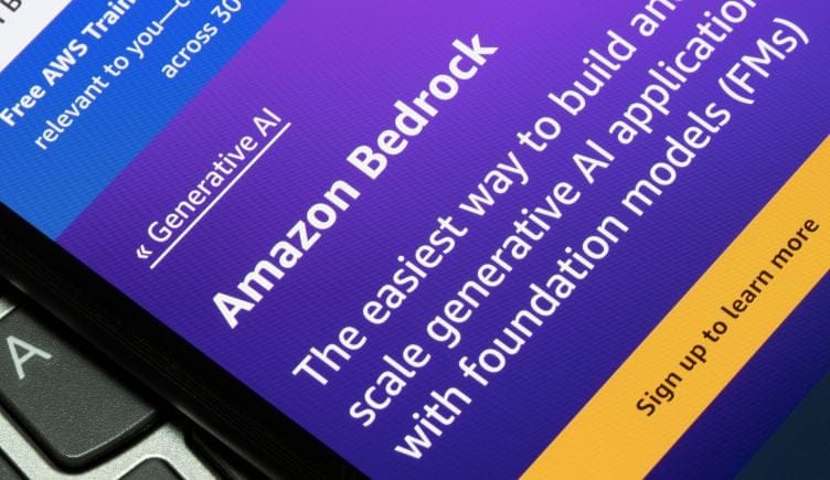 A closeup photo of a smartphone resting on a computer keyboard, and on the smartphone screen it reads the Amazon Bedrock homepage