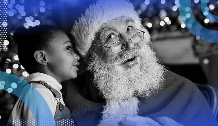 A little girl whispering in Santa’s ear.