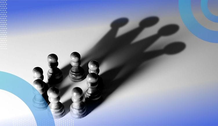 Eight chess pieces in a circle casting a shadow in the shape of a crown.