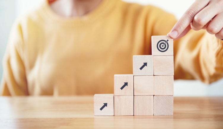 A photo of stacked blocks with arrows on them point to a target, representing career growth.