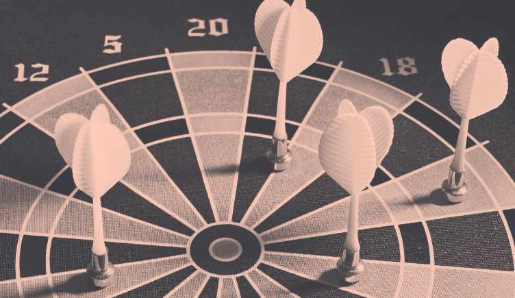Four darts that have missed their targets on the dartboard. 