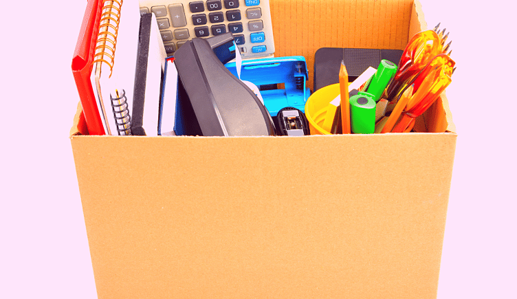 Box of office supplies on a pink background