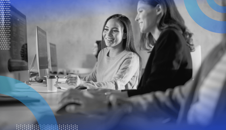 Web development image of two women looking at a computer screen together and laughing