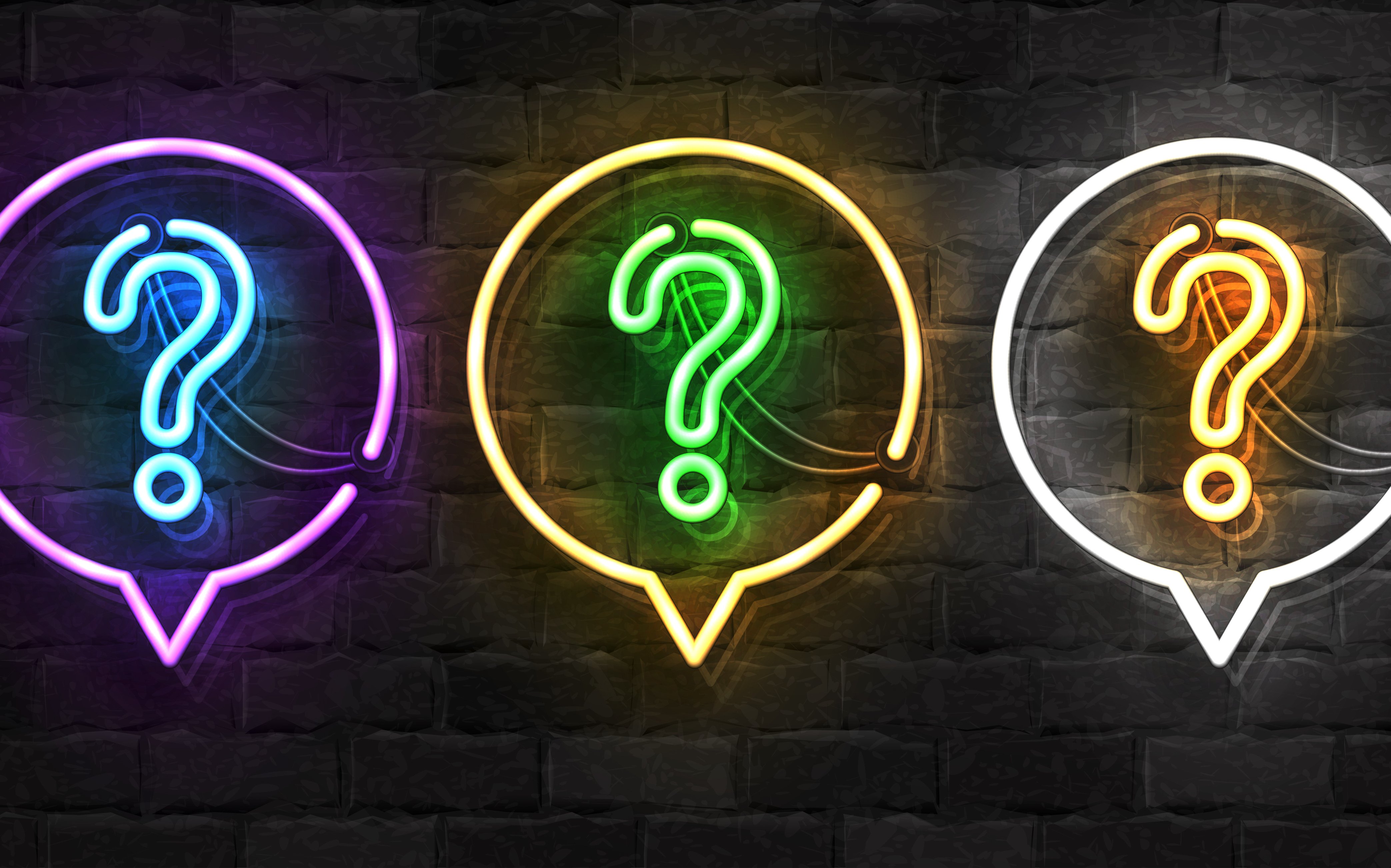 Image of brick wall with a row of three neon lights shaped like question marks within neon light speech bubbles