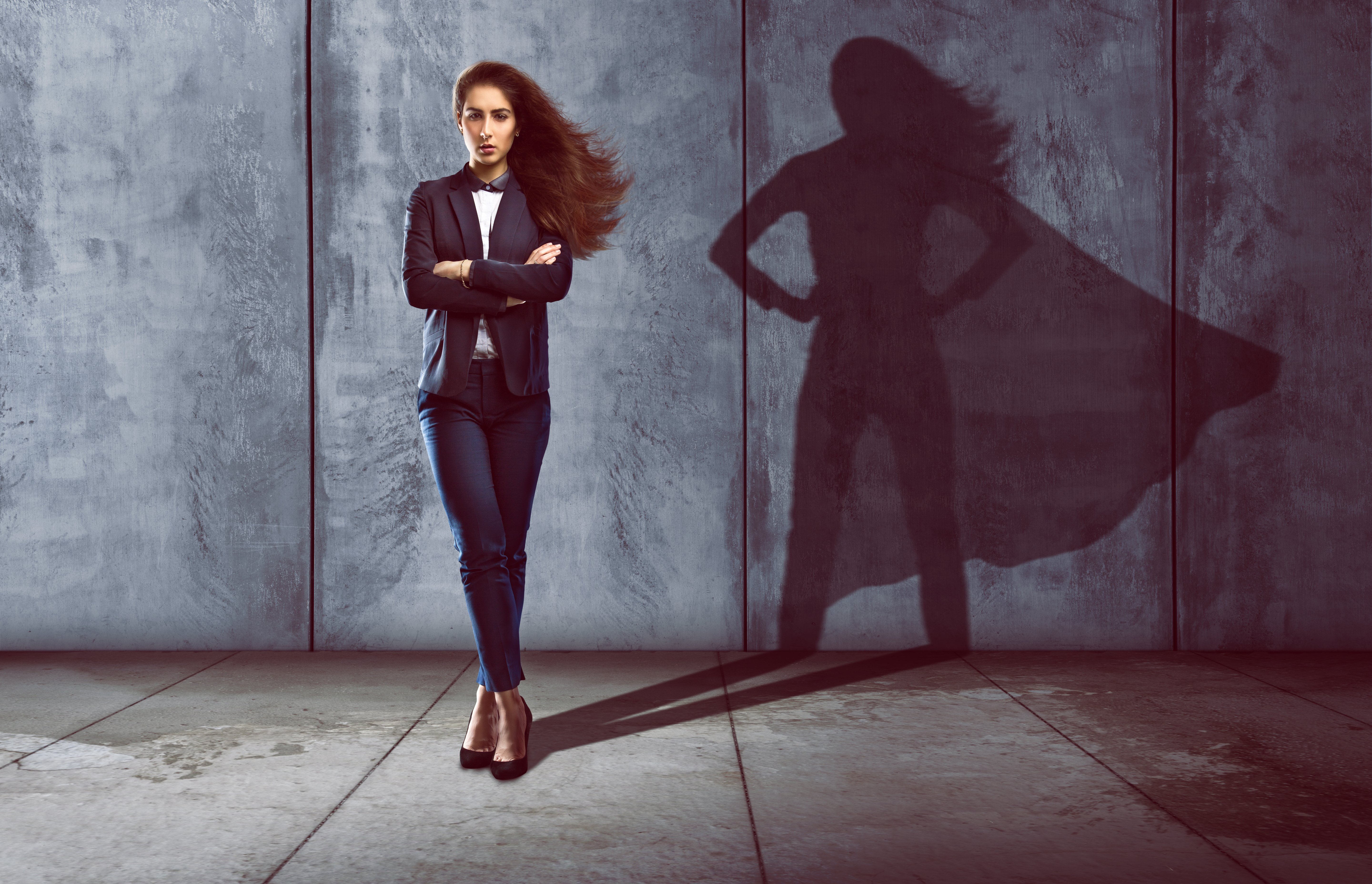 A woman with the shadow of a superhero cast behind her.