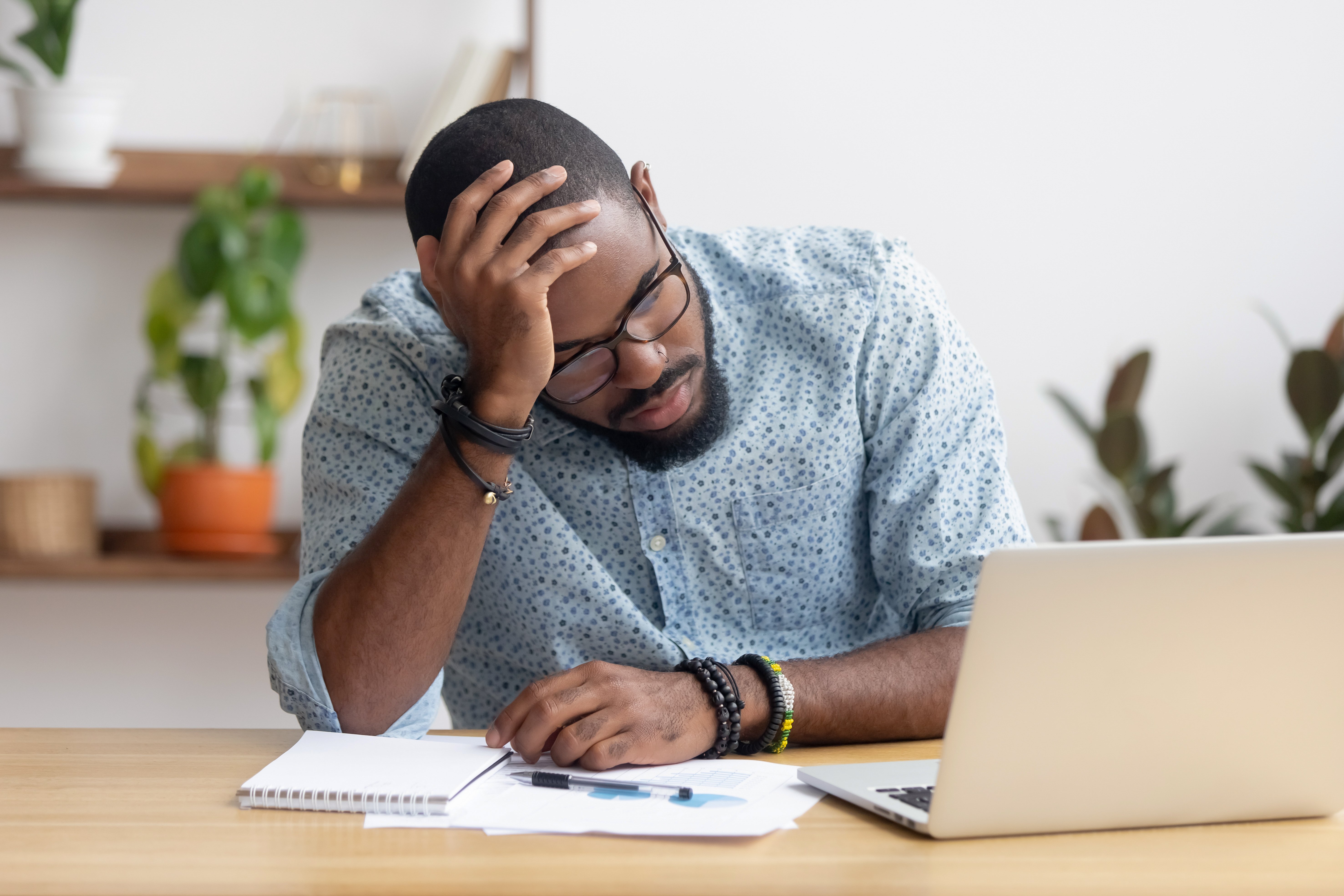 An employee holds his head in his hands in evident frustration.