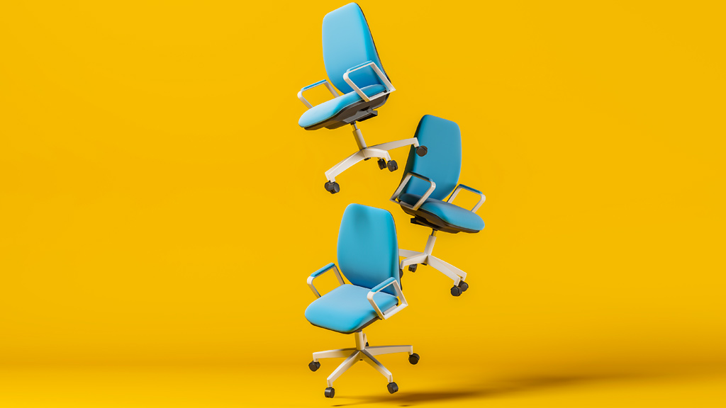 hree blue office chairs float in front of a yellow background.