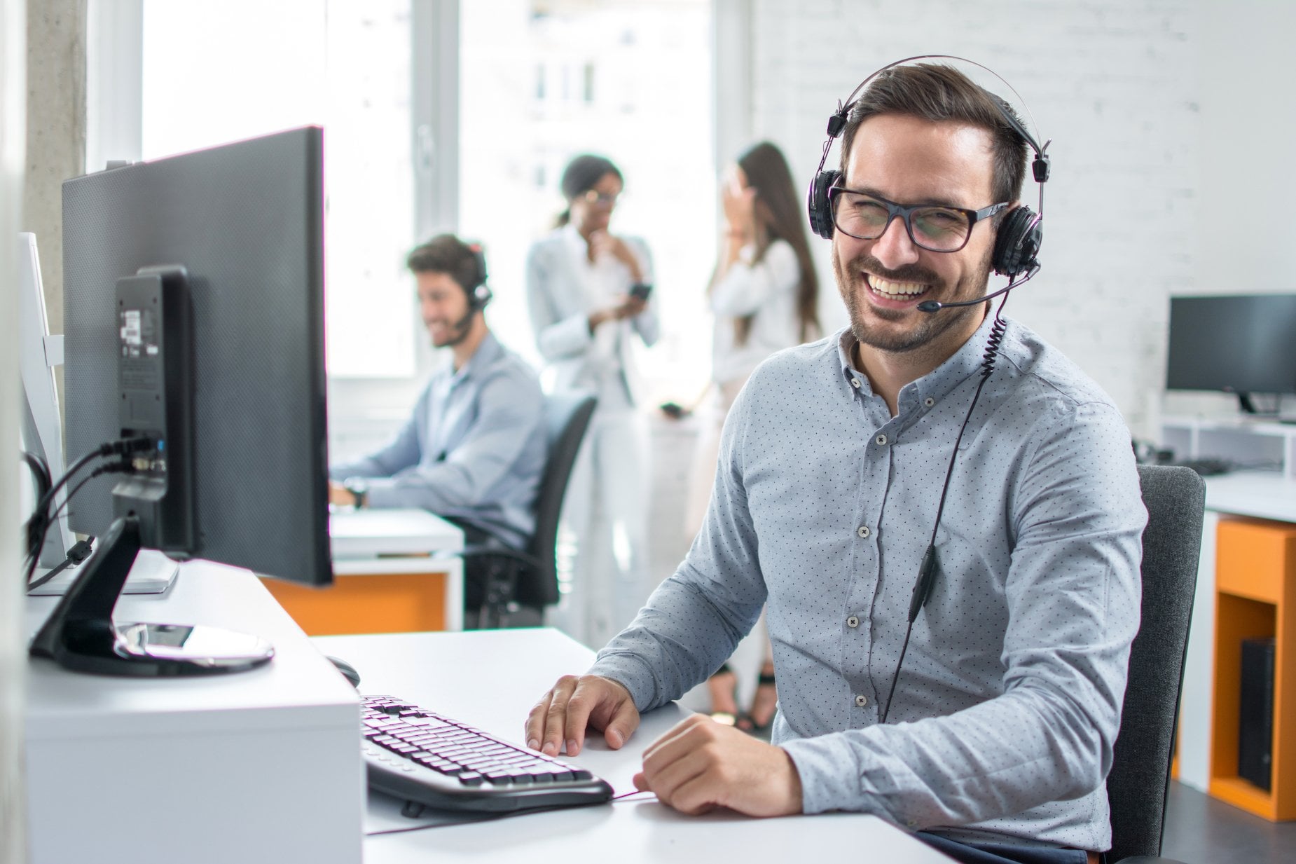 A customer success manager chats with a customer over the phone.