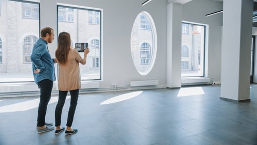 two people stand in an empty residential building