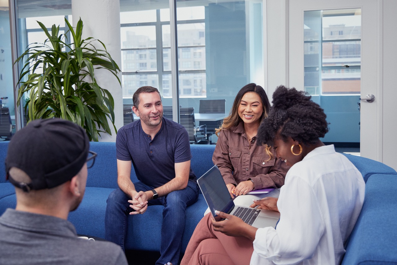 Adyen team members chatting together on couches in office