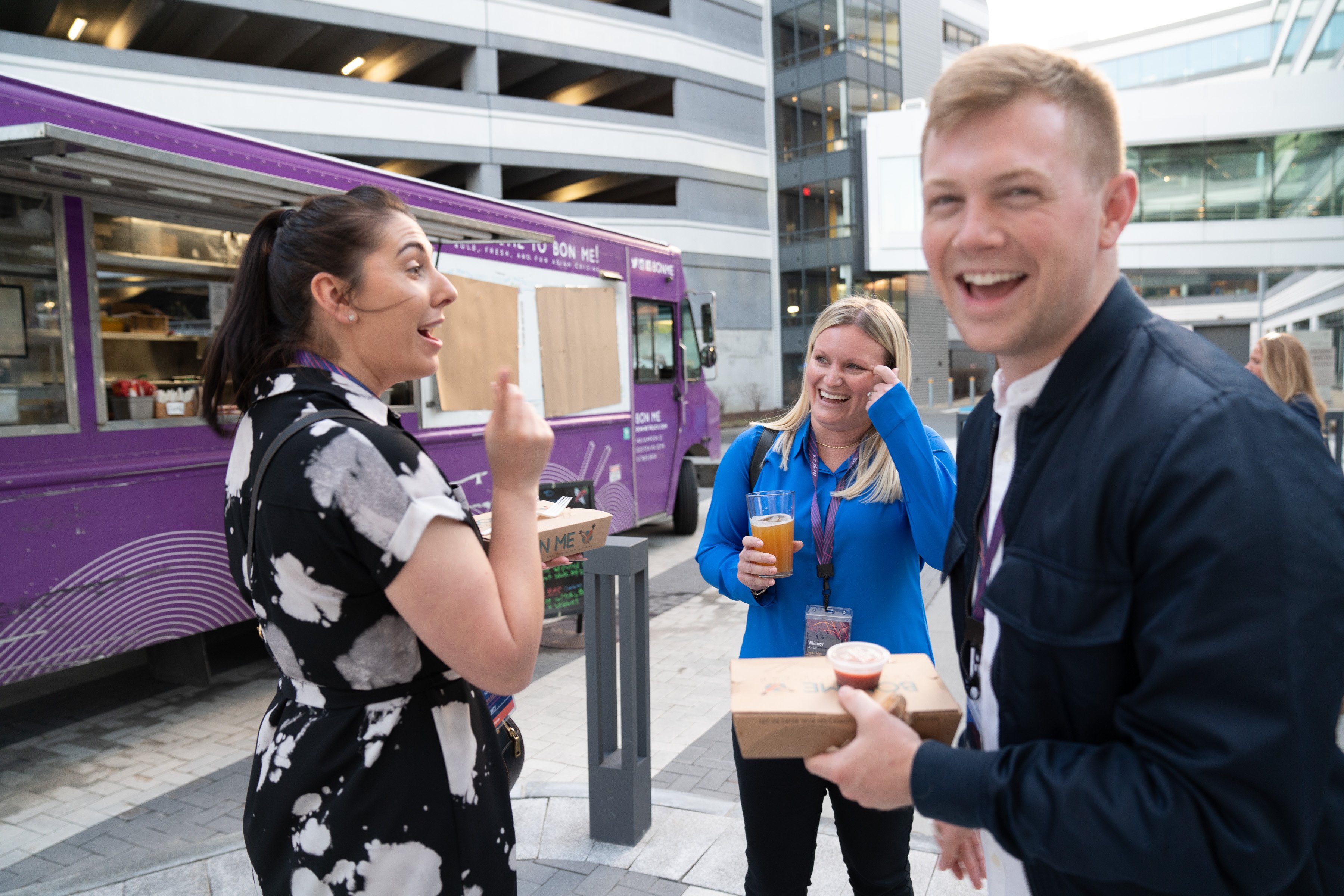 Imprivata teammates laughing together beside a food truck
