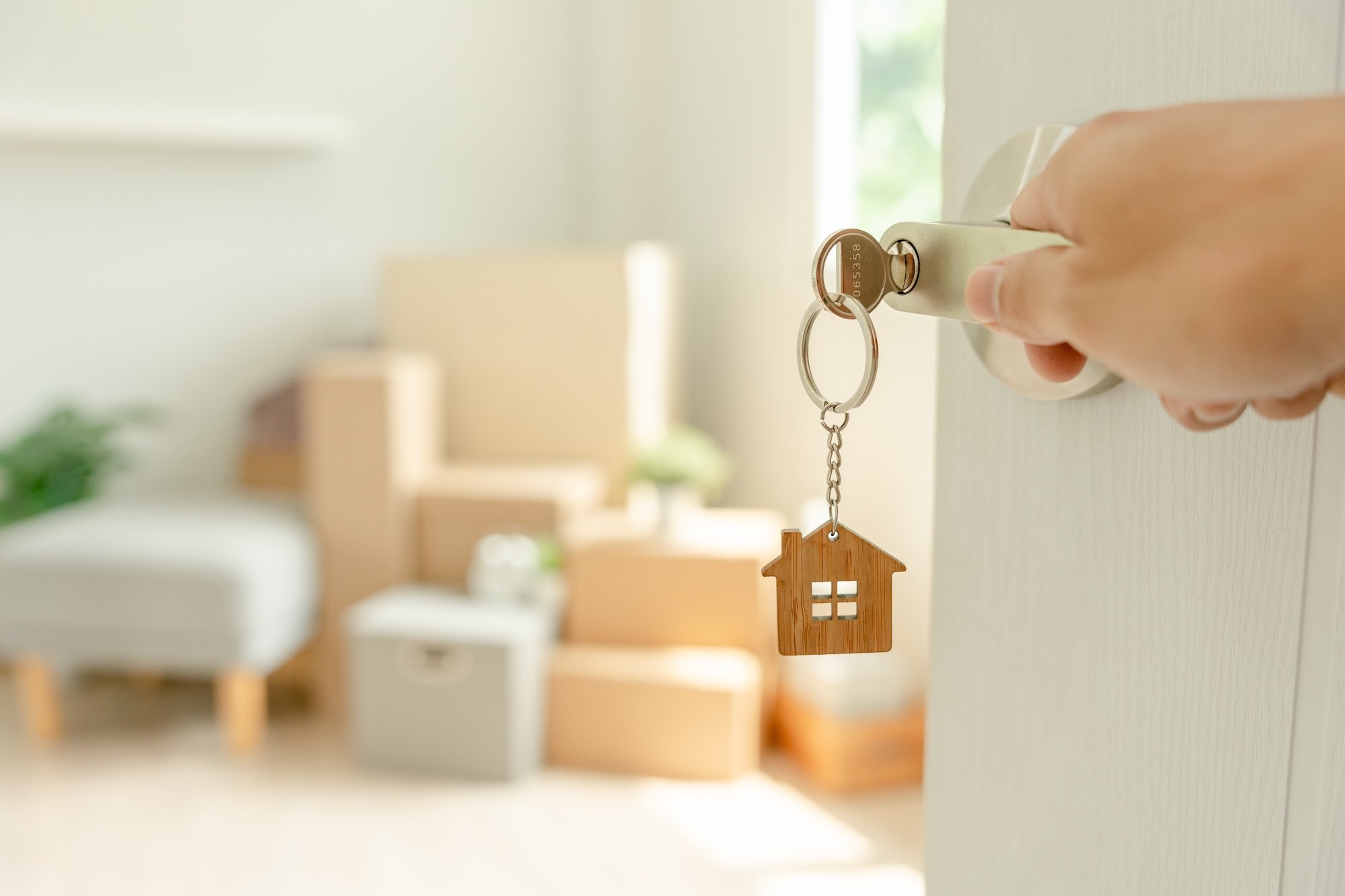 A person is pictured opening the door to a new home.