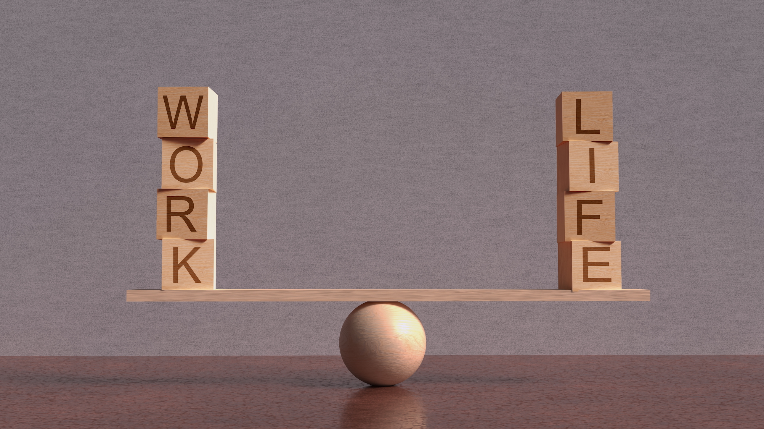 Blocks saying work and life balance on a wooden plank to show the idea of company values like work-life balance.