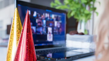party hats next to a laptop, virtual team building