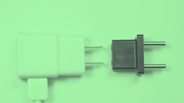A green-toned image of a USB adapter and another international plug adapter. /remote-work/5-ways-remote-teams-must-adapt