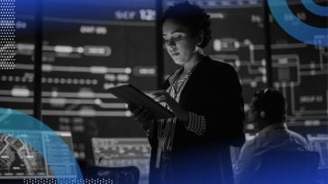 A woman uses a tablet in a data-filled command center for a public transit system. /big-data/top-roles-responsibilities-salaries