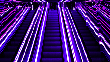 Multiple escalators with a lit passage to the top.