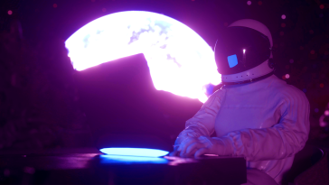 A person moonlighting as an astronaut while working on a laptop with the moon looming in the background.